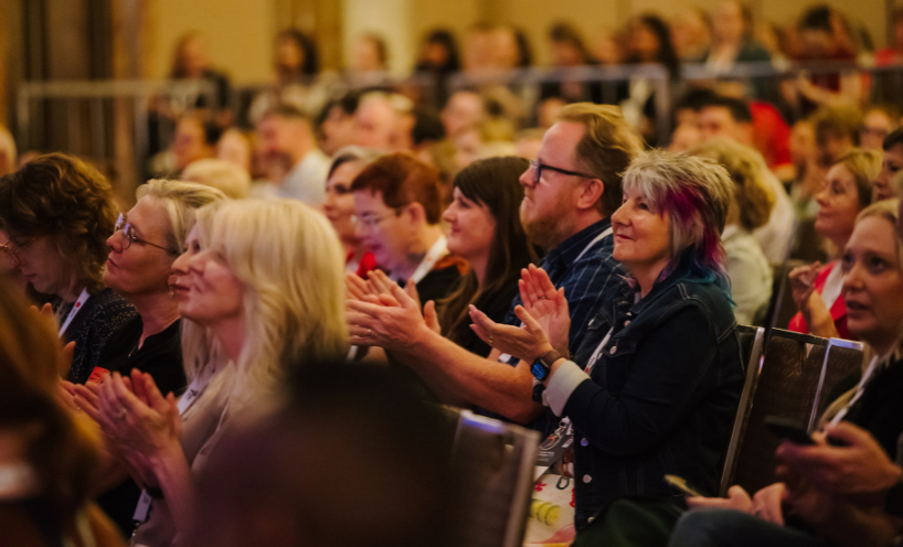 Conference attendee clapping their hands